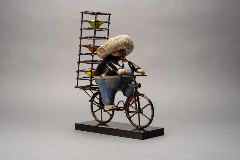 Handmade ceramic sculpture by Rodo Padilla of a joyful bird seller on a bicycle with caged songbirds – 7.1 x 2.4 x 5.9 inches – Mexican folk art honoring daily life and tradition.