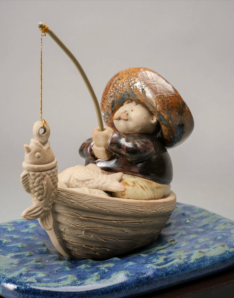 "Handmade ceramic sculpture of a fisherman in a boat with a fish on the line and a basket of fish by Rodo Padilla – Mexican folk art" 16 x 20 x 18 cm (approx. 6.30 x 7.87 x 7.09 inches)