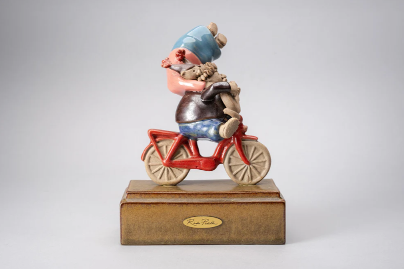Handmade ceramic sculpture by Rodo Padilla of a couple riding a bicycle, with the woman holding on joyfully – 7.1 x 2.4 x 5.9 inches – romantic Mexican folk art celebrating love and motion.
