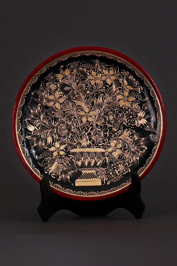 Hand-painted Mexican decorative plate with gold floral design on black background and red rim, crafted by artisans in Pátzcuaro, Michoacán