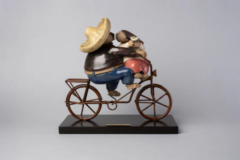 Handmade ceramic sculpture by Rodo Padilla of a couple sharing a kiss while riding a bicycle – 7.1 x 2.4 x 5.9 inches – romantic Mexican folk art piece symbolizing love and connection.