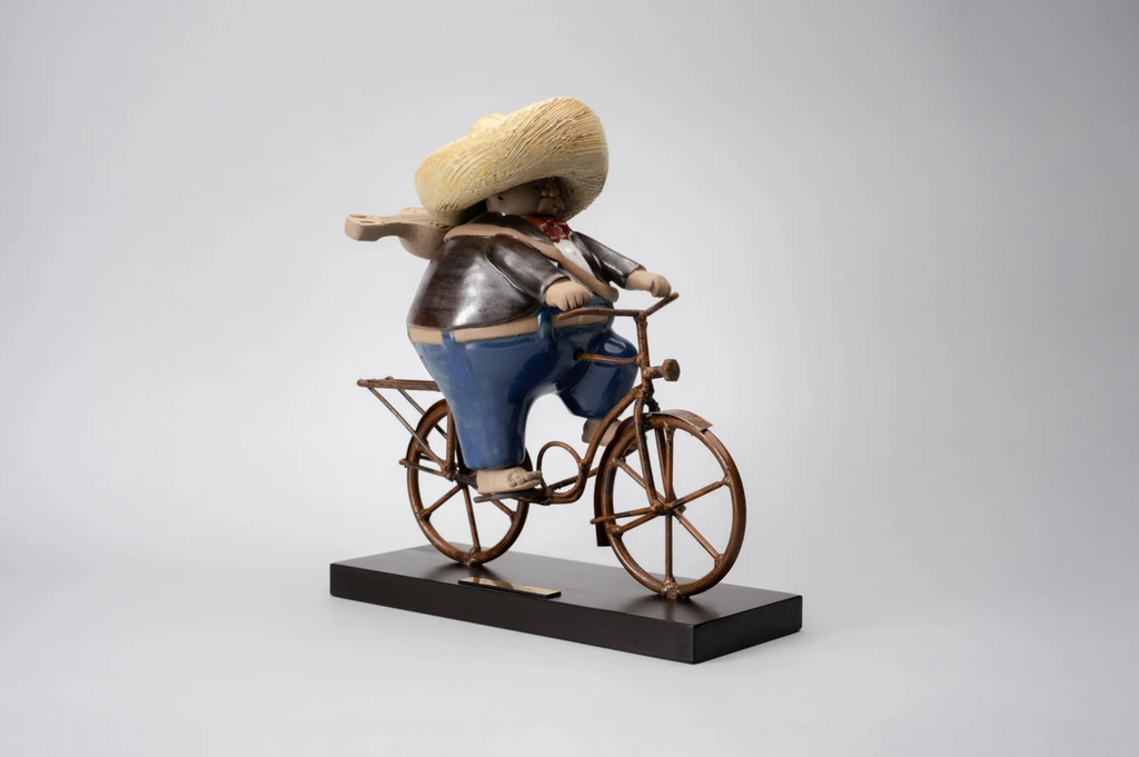 "Handmade ceramic sculpture Mariachi en Bici by Rodo Padilla featuring a joyful mariachi musician riding a bicycle with his guitar – Mexican artisan decor" 27 x 9 x 24 cm (approx. 10.63 x 3.54 x 9.45 inches)


