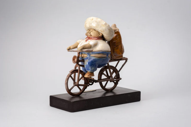 Mini handmade ceramic sculpture by Rodo Padilla of a golfer riding a bike – 3.5 x 1.6 x 3.5 inches – playful Mexican folk art perfect for sports lovers and collectors.